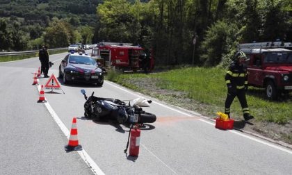 Chiazza d'olio sull'asfalto, a terra due motociclisti